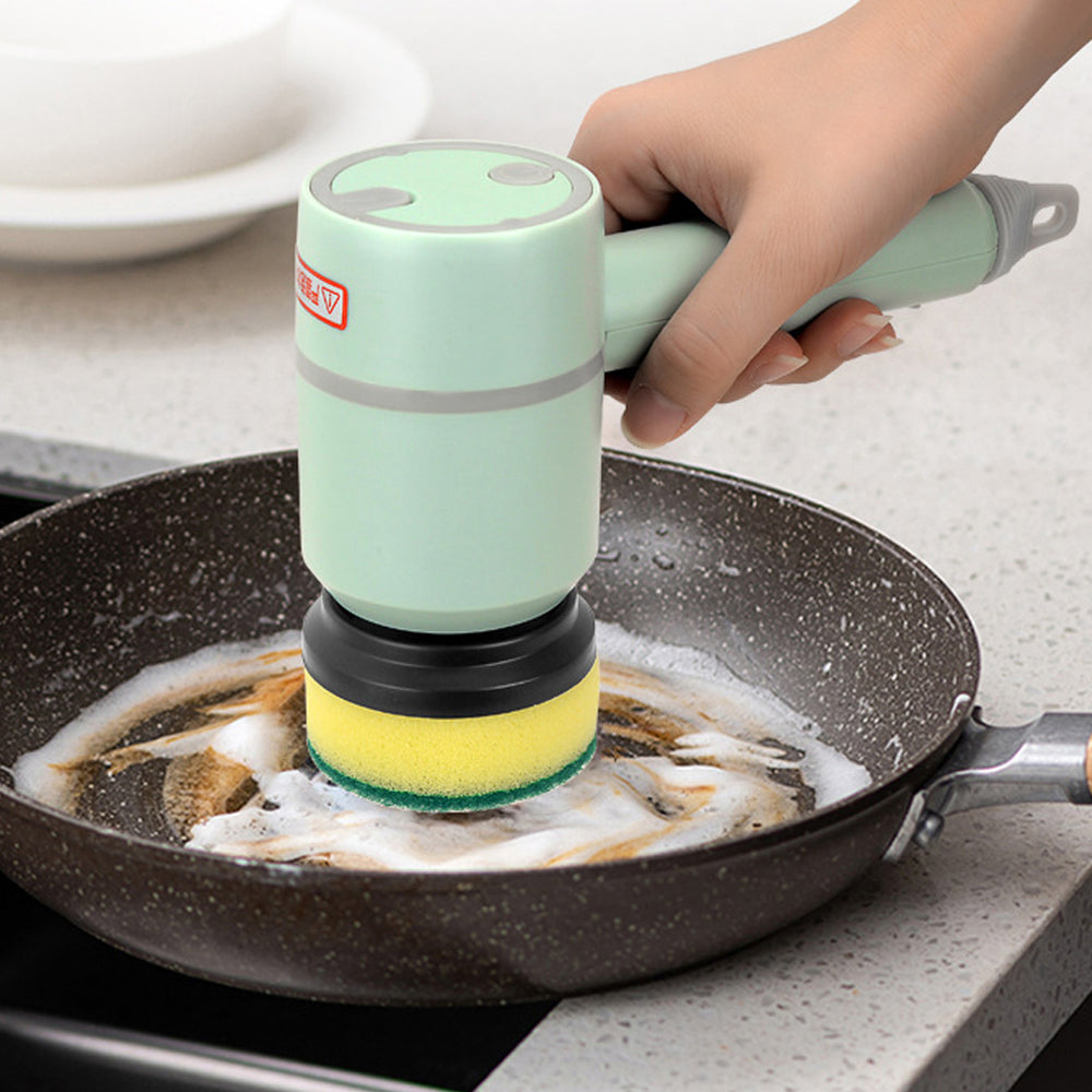 Hand using a green cleaning tool with a sponge on a frying pan